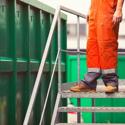 Mitarbeiter der WUbb steht an einem Container und entsorgt Altholz fachgerecht auf einem Wertstoffhof in Berlin Spandau